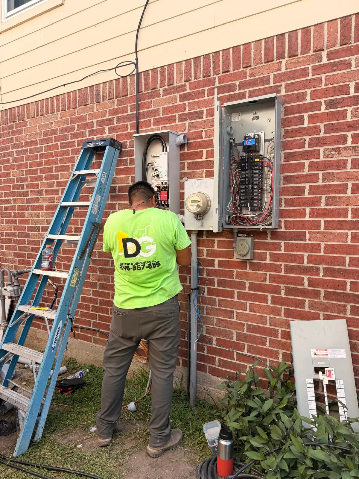 DG technician in branded uniform wiring an exterior breaker panel
