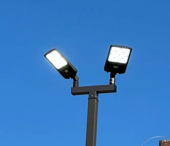 New dual LED parking-lot pole lights against a clear blue sky